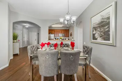 a dining room with a table with red flowers on it at Deluxe 3 Bedroom Apartment 404 in Orlando