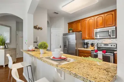 a kitchen with wooden cabinets and a granite counter top at Deluxe 3 Bedroom Apartment 404 in Orlando