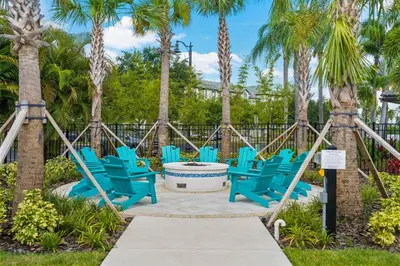a group of blue chairs on a patio with palm trees at Deluxe 3 Bedroom Apartment 404 in Orlando