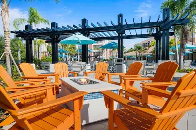 a patio with chairs and a table and umbrella at Deluxe 3 Bedroom Apartment 404 in Orlando