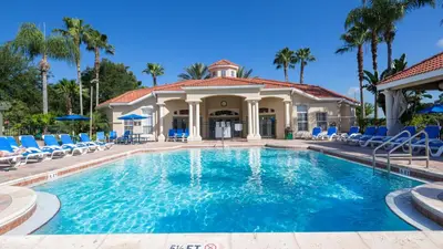 a swimming pool with chairs and a house at The Floridian 3 bed townhouse at Emerald Island Resort in Kissimmee