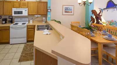a kitchen and dining room with a counter top and a table at The Floridian 3 bed townhouse at Emerald Island Resort in Kissimmee