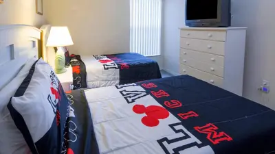 a bedroom with two beds and a dresser at The Floridian 3 bed townhouse at Emerald Island Resort in Kissimmee