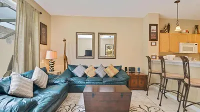 a living room with a couch and a kitchen at Minnies Townhouse in Windsor Palms Resort in Kissimmee