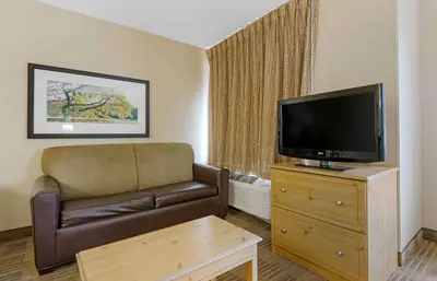 a living room with a couch and a flat screen tv at Extended Stay America Select Suites - Orlando - Southpark - Equity Row in Orlando
