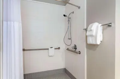 a bathroom with a shower with white towels at Nobile Hotel Parkway at Celebration Orlando Very Close to Disney Theme Parks in Orlando