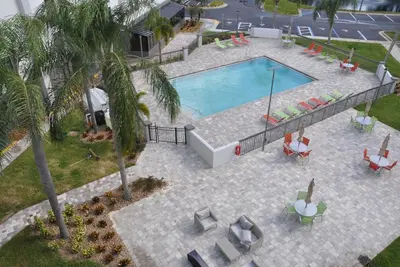 an overhead view of a swimming pool with chaises and palm trees at Nobile Hotel Parkway at Celebration Orlando Very Close to Disney Theme Parks in Orlando