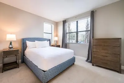 a bedroom with a bed and a dresser and a window at Siena at Bella Collina in Montverde