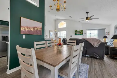 a dining room and living room with a table and chairs at Bikini Bottom - 4 bed Disney pool home in Kissimmee
