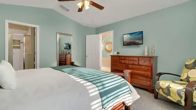 a bedroom with a bed and a dresser and a chair at Disney Backstage Villa - Stay in this popular 4 bed pool home that's very close to Disney in Orlando