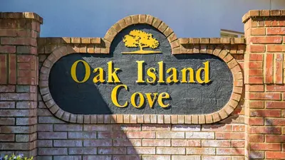 a sign for oak island cove on a brick wall at Disney Backstage Villa - Stay in this popular 4 bed pool home that's very close to Disney in Orlando