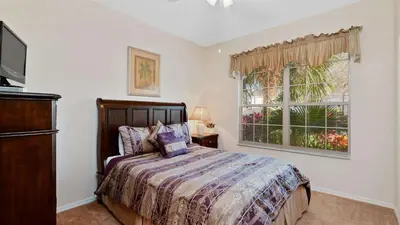 a bedroom with a bed and a window at Waterside Villa - Family 4 bed Emerald Island Resort pool home that's close to Disney World in Kissimmee