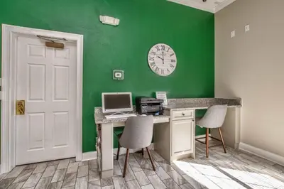 a room with a desk with a computer and a clock at Waterside Villa - Family 4 bed Emerald Island Resort pool home that's close to Disney World in Kissimmee