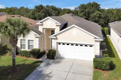 a house with a white garage at Disney Magic Vacation - A fabulous 4 bed family pool home on Windsor Palms Resort - close to Disney World in Kissimmee