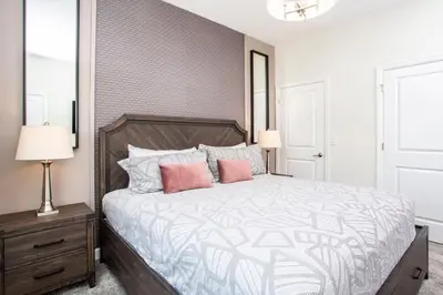 a bedroom with a large bed with pink pillows at Luxurious 4Bd Home w/ Pool 4983 in Kissimmee