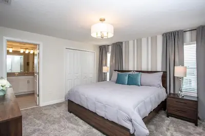 a bedroom with a large bed with blue pillows at Luxurious 4Bd Home w/ Pool 4983 in Kissimmee