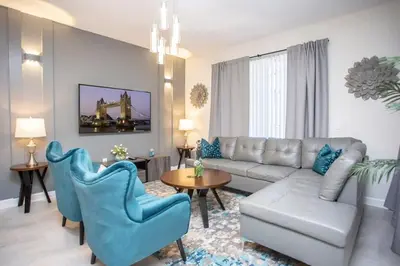 a living room with a couch and blue chairs at Luxurious 4Bd Home w/ Pool 4983 in Kissimmee