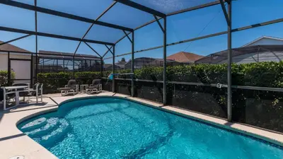 a swimming pool with a pergola next to a building at Rhapsody Palms - Family 4-bed pool home that's close to Disney in Kissimmee