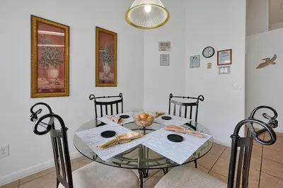 a dining room table with chairs and a glass table at Neptunes Retreat - 4 bed close to Disney in Kissimmee
