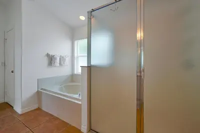 a bathroom with a bath tub and a shower stall at Neptunes Retreat - 4 bed close to Disney in Kissimmee