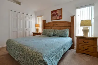 a bedroom with a bed and two lamps and a door at Neptunes Retreat - 4 bed close to Disney in Kissimmee