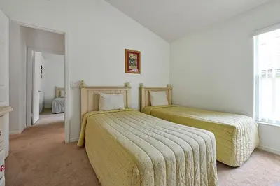 two beds in a room with white walls at Neptunes Retreat - 4 bed close to Disney in Kissimmee