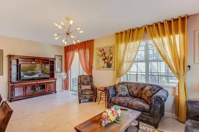 a living room with a couch and a tv at G - New 5 Bedroom Home - 5 Miles to Disney - Free Water Park - Private Pool in Kissimmee