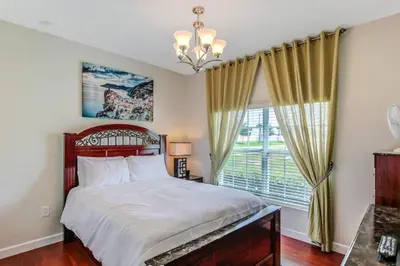 a bedroom with a bed and a large window at G - New 5 Bedroom Home - 5 Miles to Disney - Free Water Park - Private Pool in Kissimmee