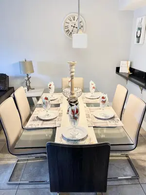 a dining table with chairs and a vase on it at Great Lovely Family Apartment close Disney in Kissimmee