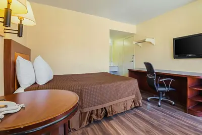 a hotel room with a bed and a desk and a table at Rodeway Inn Kissimmee - Orlando Maingate West - Free Theme Park Shuttle in Orlando