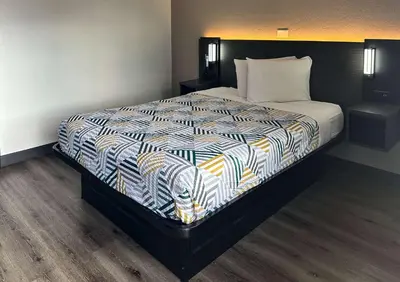 a bedroom with a bed with a colorful comforter at Motel 6-Kissimmee, FL - Orlando in Orlando