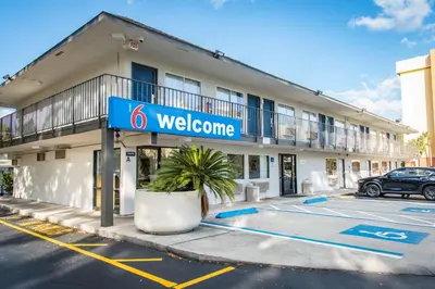 a building with a welcome sign in a parking lot at Motel 6-Kissimmee, FL - Orlando in Orlando