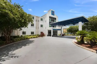 a large white building with a parking lot at Motel 6-Orlando, FL - International Dr in Orlando