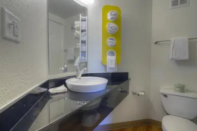 a bathroom with a sink and a toilet and a mirror at Motel 6-Orlando, FL - International Dr in Orlando