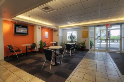 a waiting room with tables and chairs in a building at Motel 6-Orlando, FL - International Dr in Orlando