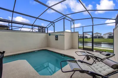 a swimming pool with two chairs and a swimming poolvisor at F - New 4 Bedroom Home - 5 Miles to Disney - Free Water Park - Private Pool in Kissimmee