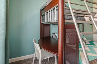 a room with a table and a bunk bed at F - New 4 Bedroom Home - 5 Miles to Disney - Free Water Park - Private Pool in Kissimmee