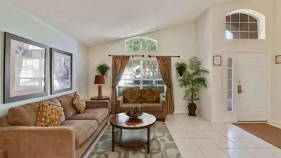 a living room with a couch and a table at Shooting Star - Family friendly 4 bed pool home on Emerald Island Resort - close to Disney World! in Kissimmee