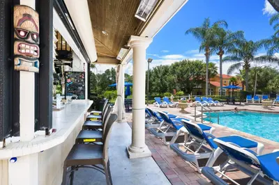 a row of lounge chairs next to a swimming pool at Shooting Star - Family friendly 4 bed pool home on Emerald Island Resort - close to Disney World! in Kissimmee
