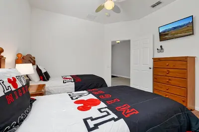 a bedroom with two beds and a dresser at Mickey's Ranch - 4 bed pool home - Windsor Hills in Orlando