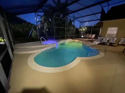 a swimming pool in a resort at night at Closest to Disney in Orlando