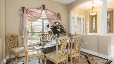 a dining room with a table and chairs and a window at Closest to Disney in Orlando