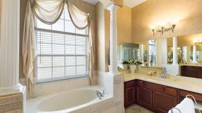 a large bathroom with a tub and a window at Closest to Disney in Orlando