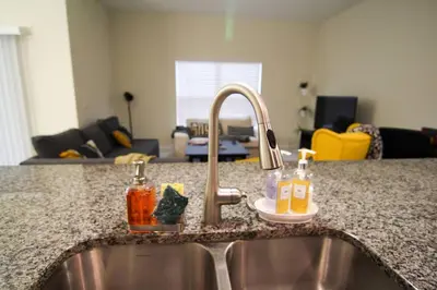 a kitchen counter with a sink and a sink at A - New 4 Bedroom Home - 5 Miles to Disney - Free Water Park - Private Pool in Kissimmee