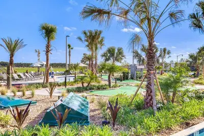 a golf course with palm trees in a resort at A - New 4 Bedroom Home - 5 Miles to Disney - Free Water Park - Private Pool in Kissimmee