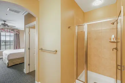 a bathroom with a shower and a bedroom at The Berkley, Orlando in Orlando