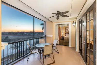 a balcony with a table and chairs and a view of the ocean at The Berkley, Orlando in Orlando
