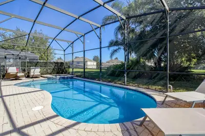 a swimming pool in a glass house with a view at Disney Daze Villa - 5 bed Windsor Hills pool home in Orlando