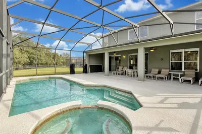 an indoor swimming pool in a house with a glass ceiling at Mickeys Sunspot - 6 bed Emerald Island Resort pool home in Kissimmee