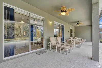 a living room with chairs and a ceiling fan at Mickeys Sunspot - 6 bed Emerald Island Resort pool home in Kissimmee